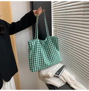 Detail of green and white gingham tote bag with a decorative bow and long shoulder straps