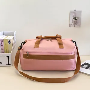 Détail du sac de sport rose avec sangles brunes et tissu résistant à l'eau