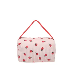 Pink corduroy makeup bag with cute strawberry pattern and red carrying handle