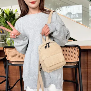 Detail of soft beige corduroy texture and zip closure on this stylish mini backpack