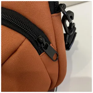 Detail of brown twill nylon fabric with black resin zipper and swivel hook connector