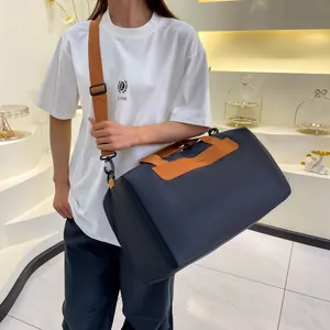 Grand sac de sport bleu avec poignées en cuir marron et bandoulière réglable pour femme