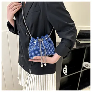 Detail van koningsblauwe strass emmertas met zilveren ketting gedragen door een model
