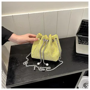 Macro-opname van gele strass emmertas met zilveren ketting en parelkoord details
