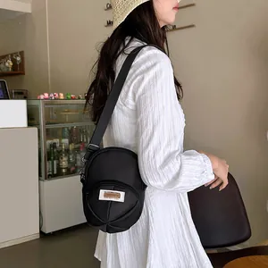 Versatile black nylon crossbody bag for women with vintage patch and zipper details
