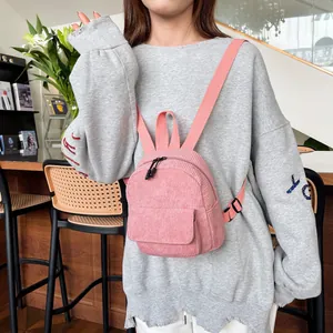 Detail of pink corduroy mini backpack featuring adjustable straps and soft ribbed texture