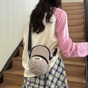 Japanese style beige nylon crossbody bag with adjustable black strap shown on a model