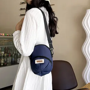 Dark blue nylon crossbody bag in a cap shape with adjustable strap for casual wear