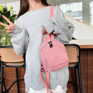 Detailed close-up of pink corduroy mini backpack with soft texture and front pocket detail