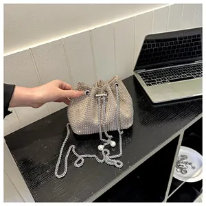 Detail van strass emmertas met zilveren trekkoord en parelketting accenten op tafel