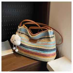 Macro shot of colorful striped straw tote with brown leather strap and cloud charm