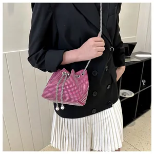 Detail van roze emmertas met strass-steentjes, parelkoord en zilveren kettingriem