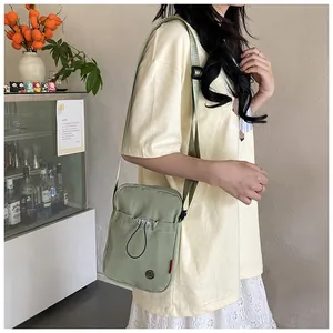 Détail du petit sac à bandoulière en nylon vert avec sangle réglable et poche à cordon
