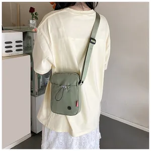 Petit sac à bandoulière en nylon vert sauge avec poche à cordon et sangle réglable