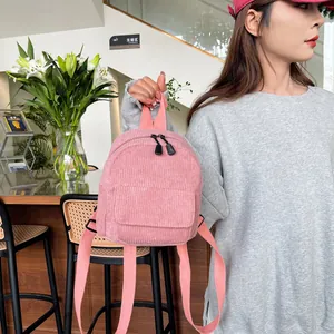 Detailed view of pink corduroy mini backpack texture and front zipper pocket detail