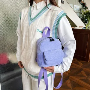 Detailed view of lavender corduroy mini backpack held by hand with webbing straps