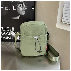 Détail du sac de téléphone en nylon vert avec poche à cordon et étiquette tissée mode