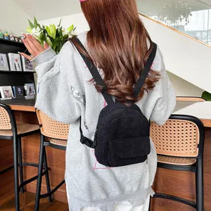 Detailed view of mini corduroy backpack showing vintage ribbed texture on back of model