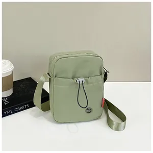 Vue détaillée du petit sac à bandoulière en nylon vert clair avec poche avant