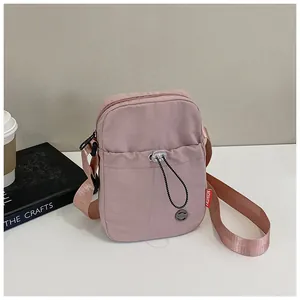 Petit sac bandoulière rose avec large sangle, présenté avec café et un livre