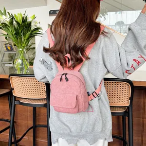 Detailed view of pink corduroy mini backpack texture and front flap pocket on model