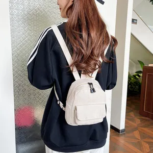 Detail of off-white corduroy mini backpack showing texture and adjustable straps