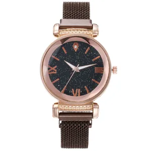 Detail of rose gold star-themed dial with Roman numerals and mesh bracelet on women's watch