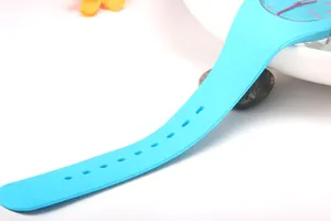 Detailed close-up of light blue silicone watch strap and Geneva brand dial on a desk