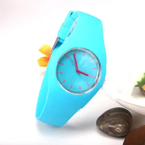 Sky blue Geneva quartz watch with silicone strap and red hands on a textured white surface