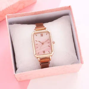 Detail view of square rose gold ladies watch with mesh band in a textured gift box