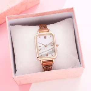 Detail of rose gold rectangular watch with marble dial in a pink gift box