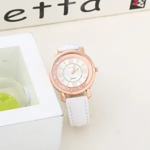 Detail showing rose gold watch with floating rhinestones and white leather strap