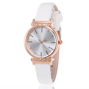 Détail du boîtier de montre or rose avec strass et bracelet en cuir blanc élégant
