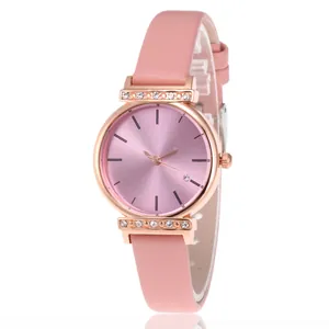 Détail du boîtier de montre or rose avec cristaux et texture du bracelet en cuir rose