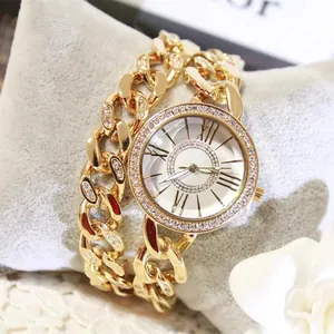 Nahaufnahme einer goldenen Quarzuhr mit Strass und römischen Ziffern auf Samtkissen