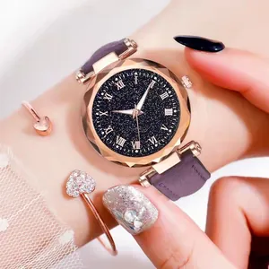 Gros plan d'une montre cadran étoilé avec chiffres romains et bracelet cœur