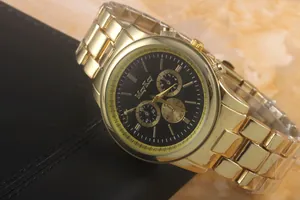 Detailed close-up of a gold-plated metal watch with black dial and three sub-dials