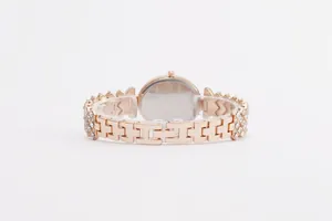 Detail of rose gold luxury watch with H-link metal strap and crystal-set case back view