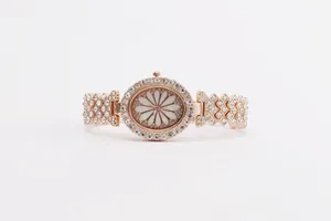 Macro shot of rose gold floral dial with crystal pavé V-shaped bracelet and jewelry watch