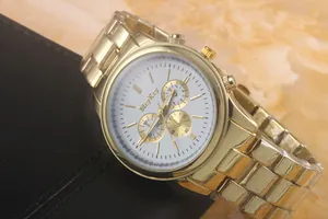 Macro detail of gold stainless steel watch band with a white quartz chronograph dial