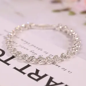 Dettaglio del bracciale d'argento a forma di cuore con zirconi su carta bianca elegante