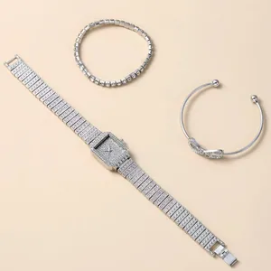 Detail of silver square watch set with shimmering tennis bracelet and infinity bangle