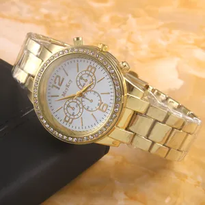 Gold quartz watch with rhinestone bezel and white dial on a black gift box