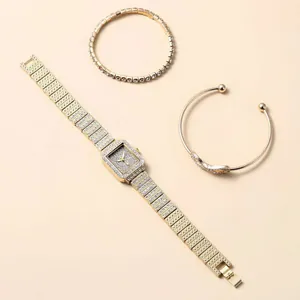 Detail shot of a square gold watch set with crystal-inlaid bracelets and bow bangle
