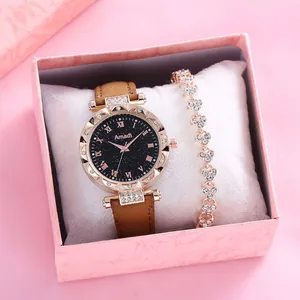 Detalle del reloj con esfera estrellada y pulsera de corazón en caja de regalo rosa