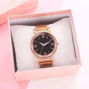 Macro shot of rose gold mesh watch with starry black dial in pink marble gift box