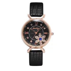 Close-up of women's black leather watch with rose gold case and gold snowflake dial detail