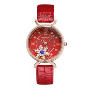 Detailed view of red crocodile pattern leather strap and snowflake dial on women's watch