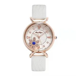 Macro detail of rose gold watch face with snowflake design and blue gemstone