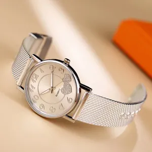 Detail einer silbernen Mesh-Uhr mit champagnerfarbenem Zifferblatt und Herzakzenten